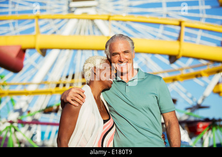 Portrait of hugging senior couple at amusement park Stock Photo