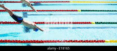 Swimmers diving into pool Stock Photo