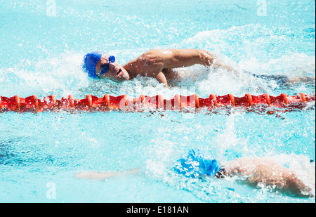 Swimmers racing in pool Stock Photo