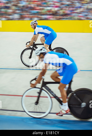 Track cyclists riding in velodrome Stock Photo