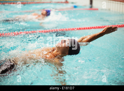 Swimmers racing in backstroke in pool Stock Photo