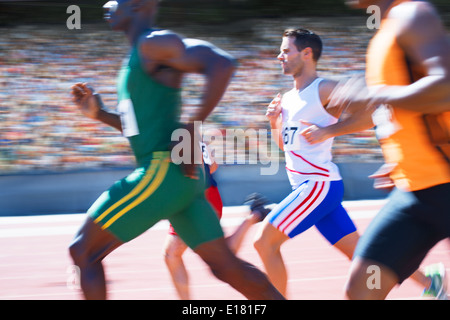 Track-and-field athletics. Young Caucasian woman, professional athlete,  runner training at public stadium, sport court, outdoors. Concept of sport,  achievment, motion. Stock Photo