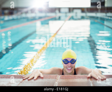 Portrait of smiling swimmer at edge of pool Stock Photo