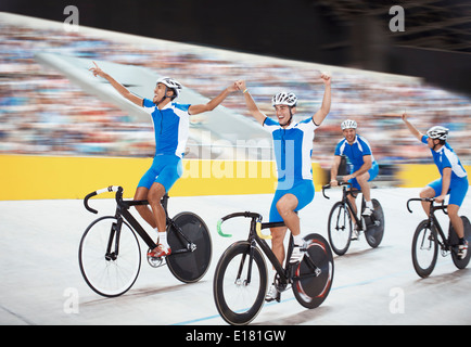 Track cycling team celebrating in velodrome Stock Photo