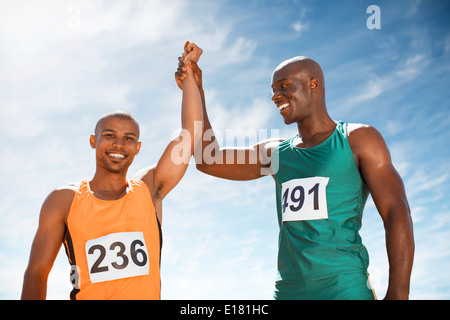 Athletes celebrating together on track Stock Photo
