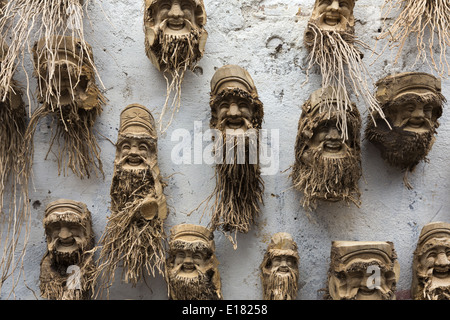 Sale of crafts. Masks made from tree root. Stock Photo