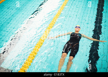 Swimmer floating in pool Stock Photo