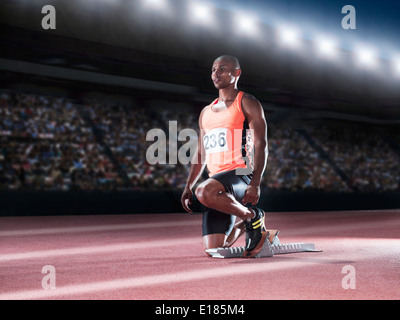 Runner with feet in starting block on track Stock Photo