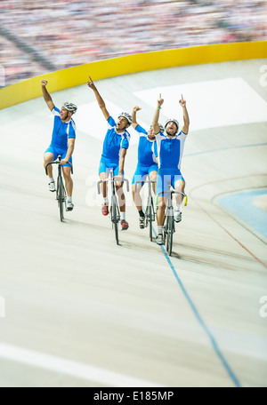 Track cycling team celebrating in velodrome Stock Photo