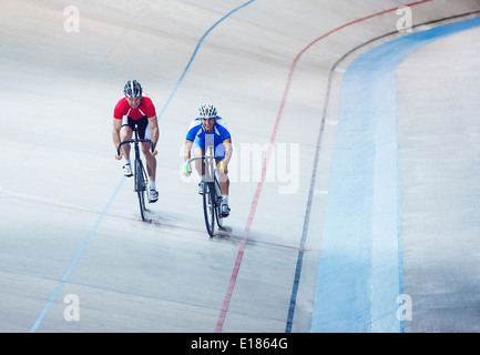 Track cyclists riding in velodrome Stock Photo