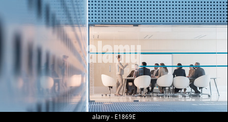 Businesswoman leading meeting in modern conference room Stock Photo