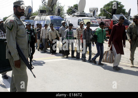 Lahore. 26th May, 2014. A Pakistani soldier stands guard as released Indian fishermen line up before crossing Wagah Border in eastern Pakistan's Lahore, May 26, 2014. Pakistan handed over 151 Indian prisoners to Indian authorities as a 'goodwill gesture' on Monday. Credit:  Jamil Ahmed/Xinhua/Alamy Live News Stock Photo