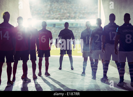 Silhouette of soccer teams facing field Stock Photo