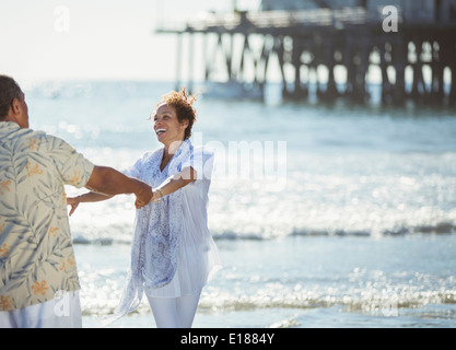 Enthusiastic couple dancing on sunny beach Stock Photo