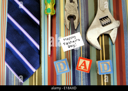 Collection of tools with tie and Fathers Day tag over a masculine patterned background Stock Photo