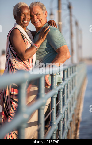 Portrait of smiling senior couple hugging on pier Stock Photo