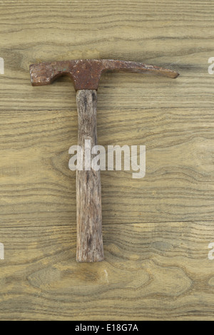 Vertical photo of an old masonry hammer on aged wood Stock Photo