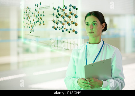 Serious doctor with clipboard in hospital corridor Stock Photo