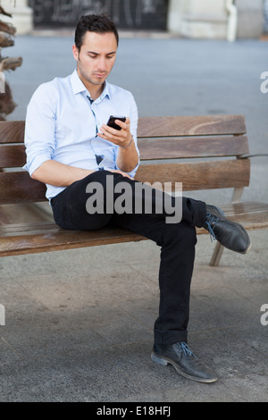 Good-looking man checking his smartphone Stock Photo
