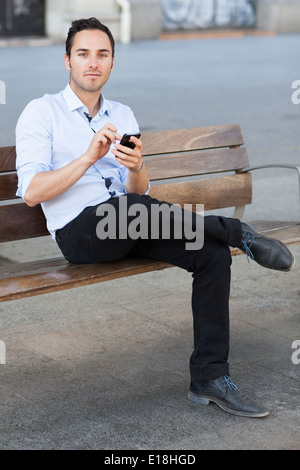 Good-looking man checking his smartphone Stock Photo