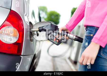 Lady pumping gasoline fuel in car at gas station. Stock Photo