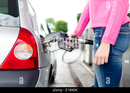 Lady pumping gasoline fuel in car at gas station. Stock Photo