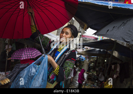 A woman belonging to the H'Mong ethnic group with an umbrella, in the market of Sapa Stock Photo