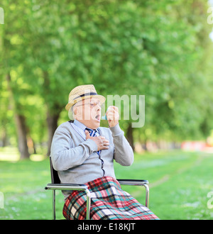 Senior man having an asthma attack in park Stock Photo
