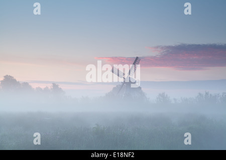 windmill in dense morning fog, Netherlands Stock Photo