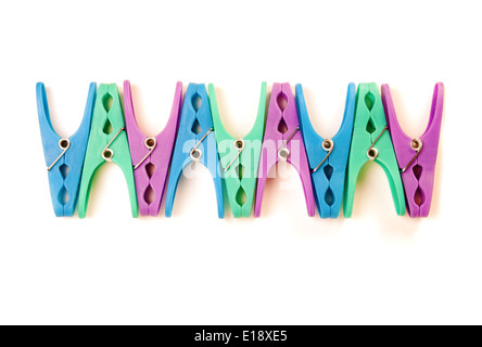 Row of coloured plastic clothes pegs on a white background Stock Photo