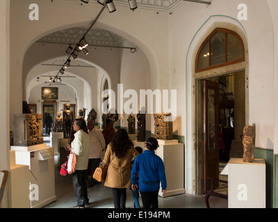 India, Rajasthan, Jaipur, Albert Hall Museum, visitors looking at exhibits in wood carving gallery Stock Photo