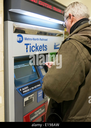 Man Purchasing Metro North Transit Train Tickets at Self Serve Vending Machine, Grand Central Terminal, NYC Stock Photo