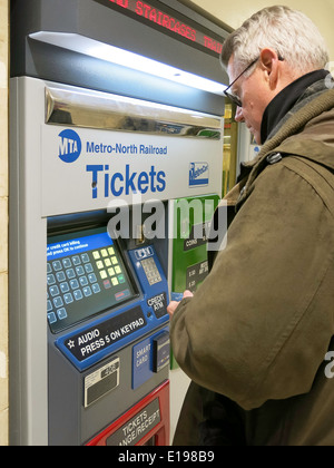 Man Purchasing Metro North Transit Train Tickets at Self Serve Vending Machine, Grand Central Terminal, NYC Stock Photo