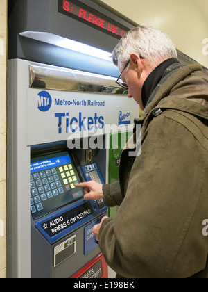 Man Purchasing Metro North Transit Train Tickets at Self Serve Vending Machine, Grand Central Terminal, NYC Stock Photo