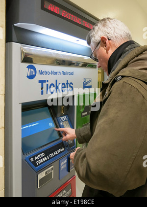 Man Purchasing Metro North Transit Train Tickets at Self Serve Vending Machine, Grand Central Terminal, NYC Stock Photo