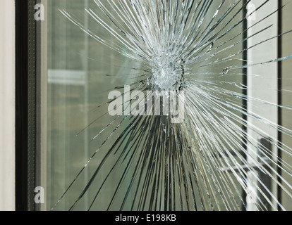 Broken glass window smashed by accident or after a break in, great for an insurance claim. Stock Photo