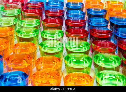 Various alcoholic shots in shot glasses creating multi colored drinks industry background Stock Photo