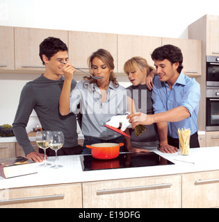 Group Of Young Friends Preparing Breakfast In Modern Kitchen Stock Photo