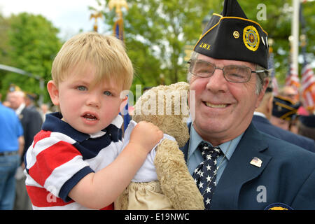 Merrick, New York, USA. 26th May, 2014. GARY GLICK, a member of American Legion Post 1282, holds his grandson MAX, almost 2, after the veteran marched in the Merrick Memorial Day Parade, which honored those who died in war while serving in the United States military. © Ann Parry/ZUMA Wire/ZUMAPRESS.com/Alamy Live News Stock Photo