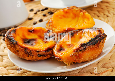a plate with pasteis de nata, typical Portuguese egg tart pastries on a set table Stock Photo