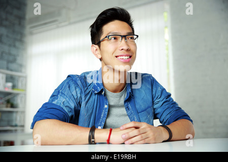 Young happy asian man sitting at the table Stock Photo