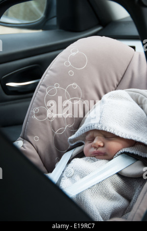 View of a baby sitting in car seat through back door Stock Photo