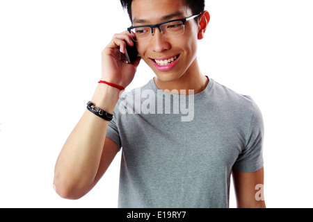 Portrait of a young cheerful asian man talking on the phone over white background Stock Photo