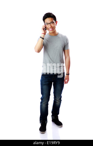 Young cheerful asian man talking on the phone over white background Stock Photo