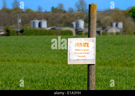 Warning sign. 'Private: Please keep out. This is not a public footpath' at a farm in Kent, England. Stock Photo