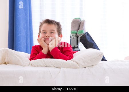 Eight years old kid cheerfully enjoying the morning with Chrismast colors red shirt and green socks Stock Photo