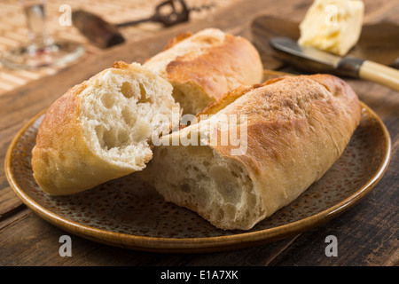 French bread baguette and butter on a rustic wooden tabletop. Stock Photo
