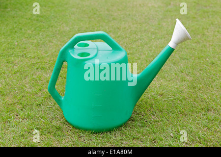 A green plastic garden watering can on a lawn, Scotland, UK Stock Photo