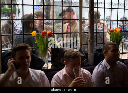 Inside and outside view of customers drinking and socialising at the Newman Arms pub in Fitzrovia, London, UK. Stock Photo