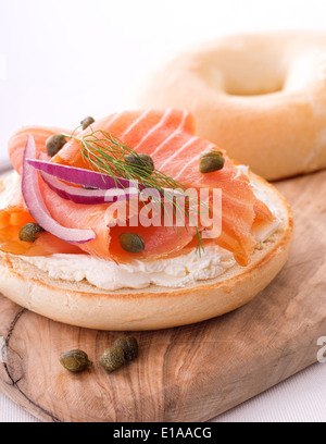 A delicious bagel with smoked salmon lox, cream cheese, red onion, capers, and a sprig of dill.
